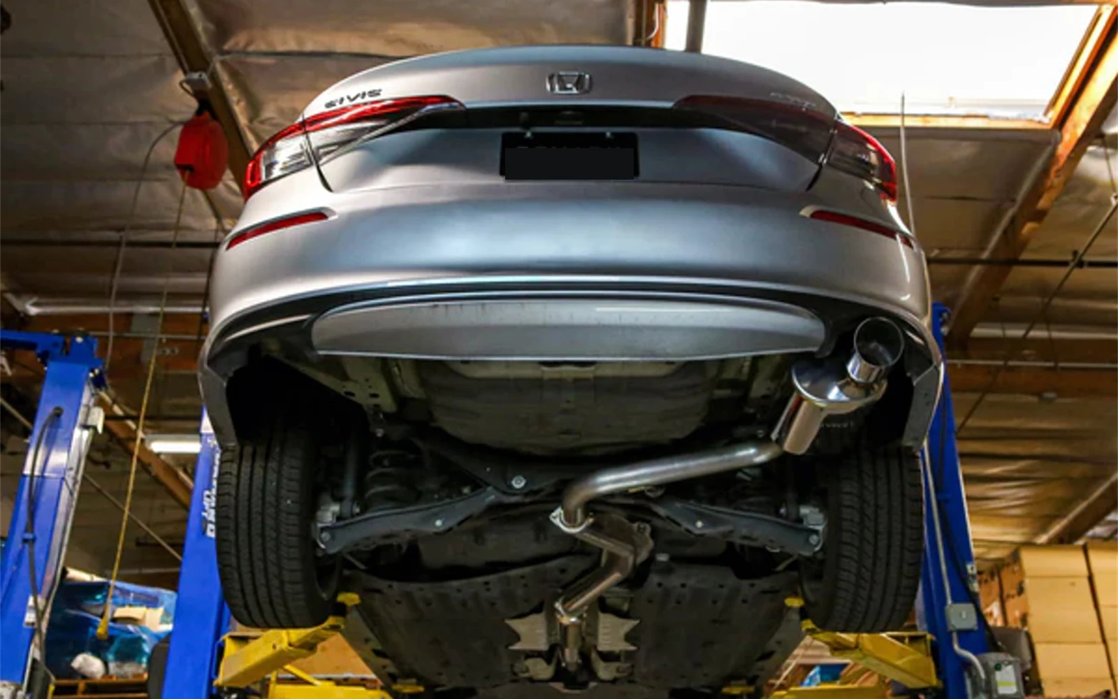 Honda Civic novo suspenso em elevador automotivo na oficina mecânica em Osasco exibindo a parte de baixo da suspensão e freios ABS